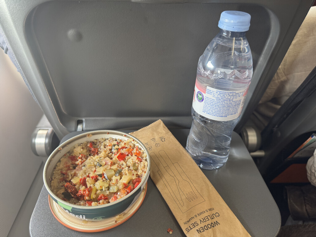 a bowl of food and a bottle of water on a chair