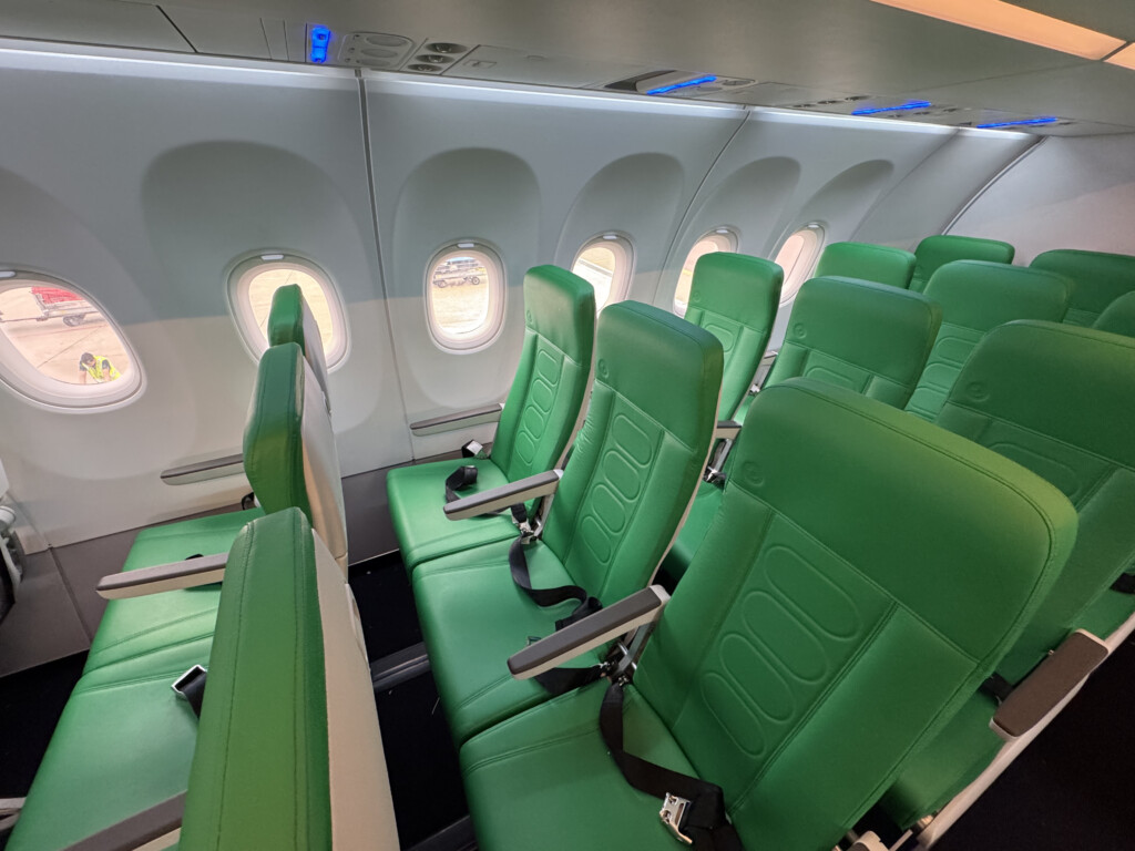 a row of green seats in an airplane