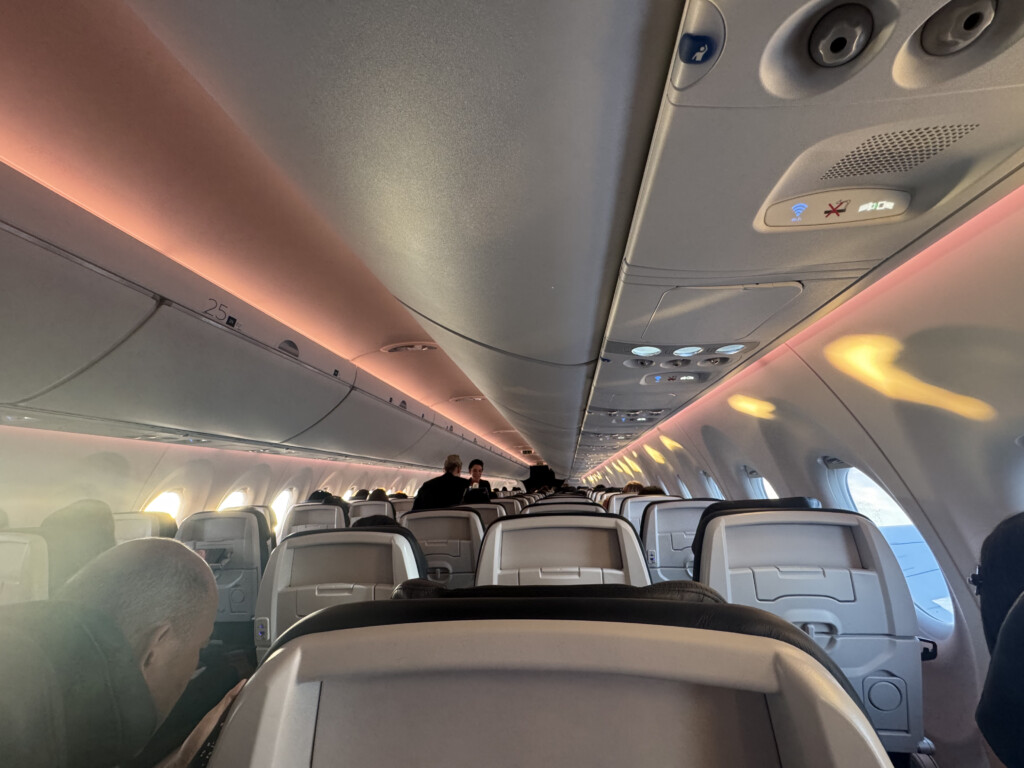 inside an airplane with people sitting on the seats