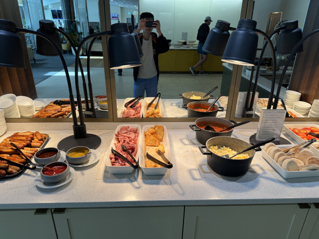 a person taking a picture of food in a buffet