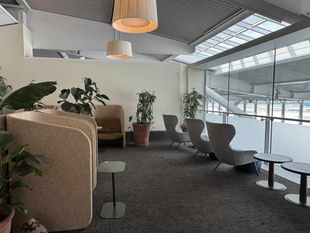 a room with chairs and tables and plants