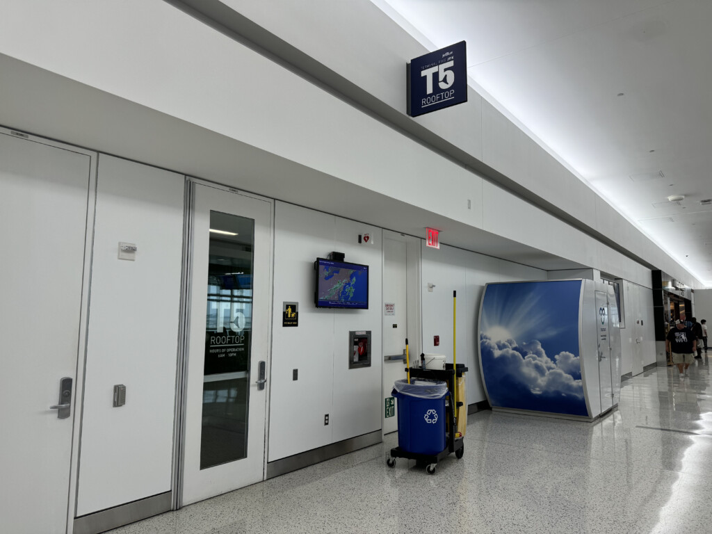 a white hallway with white doors and a blue mop