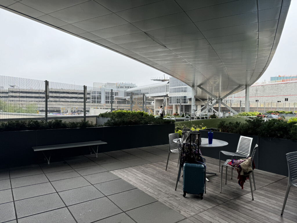 a patio with chairs and a table and luggage