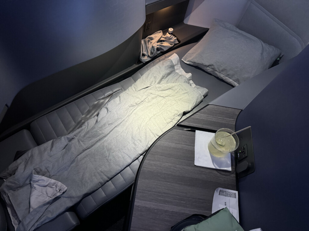 a bed with a drink on a table