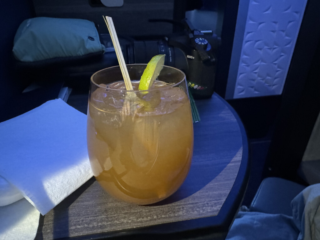 a glass with a drink and a lime slice on it
