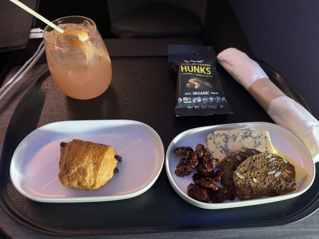 food on a tray with a drink and a drink in the background