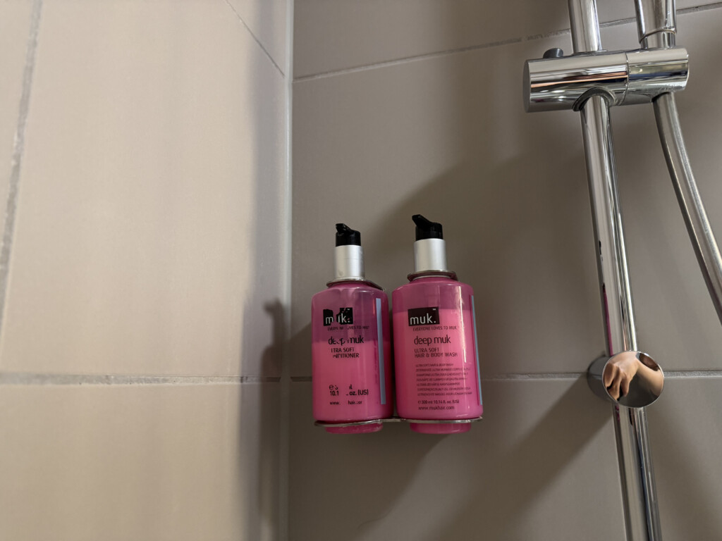 a couple of pink bottles on a shower
