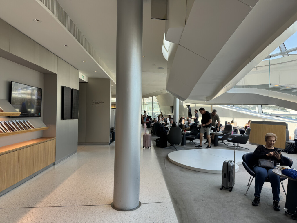 a group of people in a room with a large column