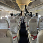 a person standing in the aisle of an airplane