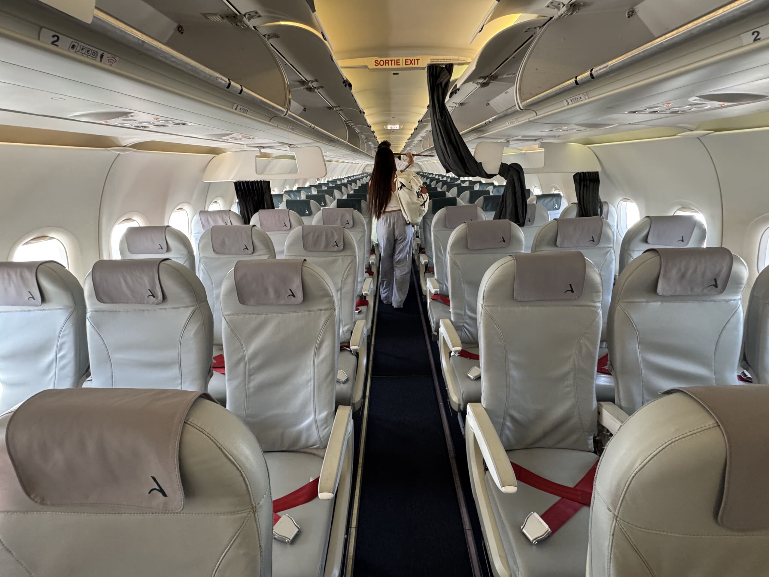 a person standing in the aisle of an airplane