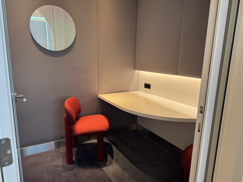 a red chair next to a white desk