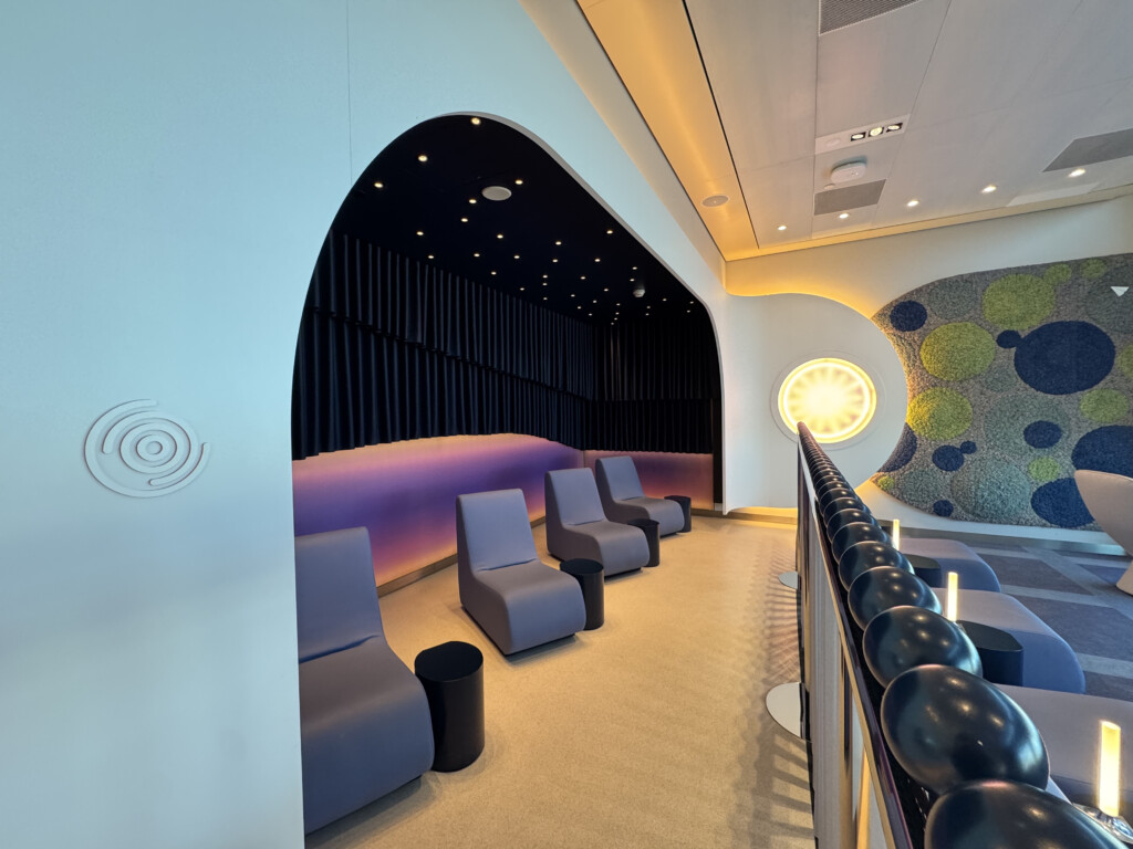 a room with chairs and a wall with a black curtain