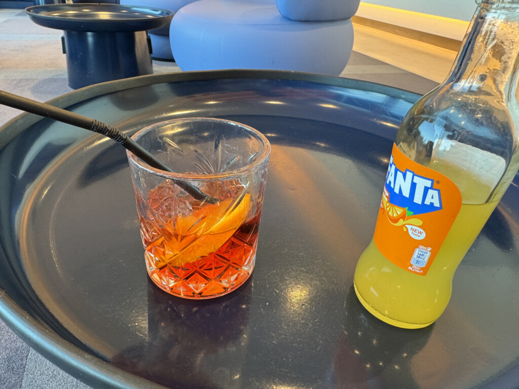 a glass with a straw and a lemon on a tray