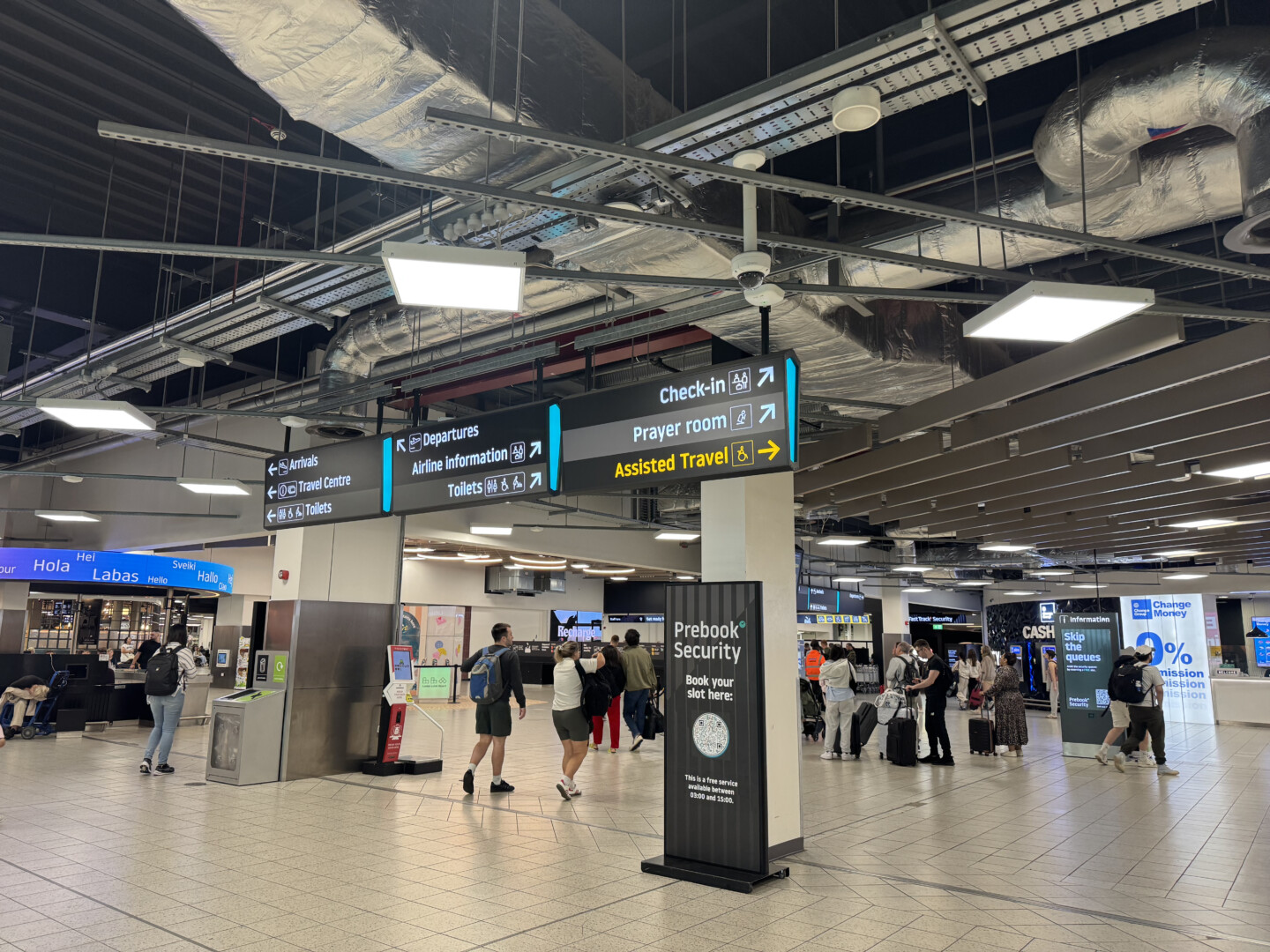 people in a terminal with signs and people walking