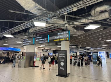 people in a terminal with signs and people walking