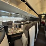 a inside of an airplane with chairs and tables