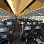an airplane with rows of seats and monitors