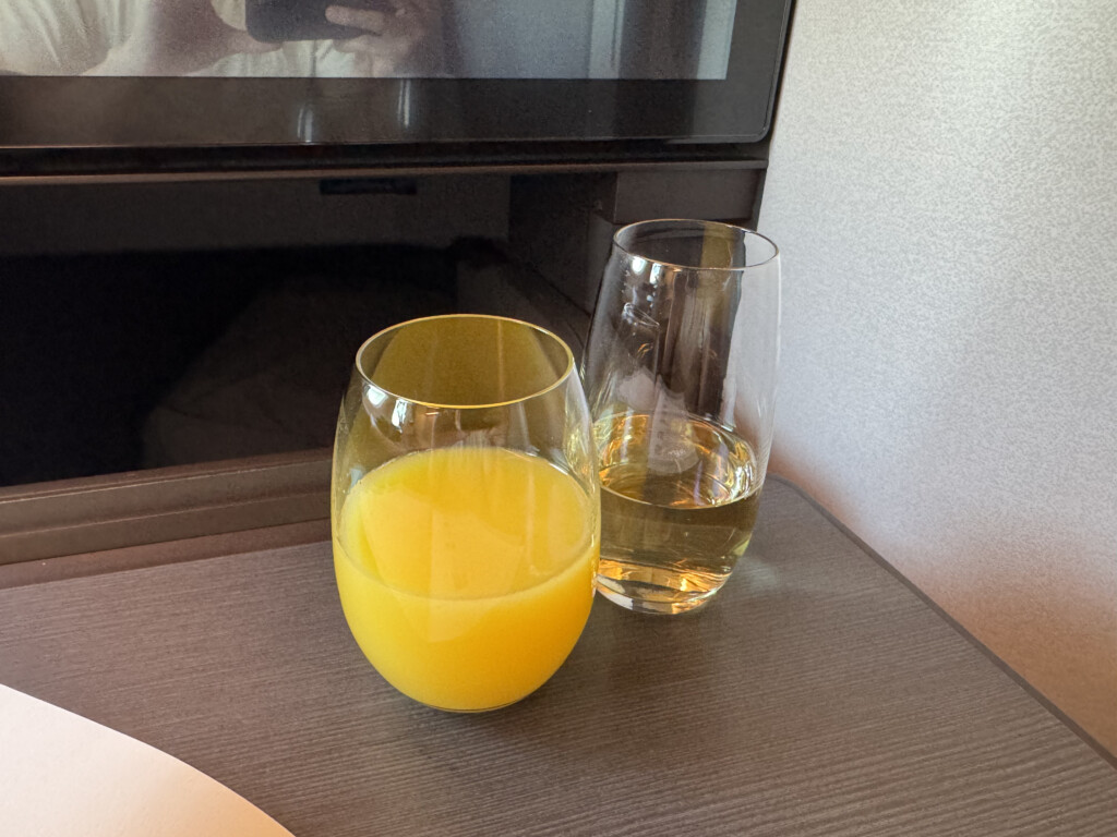 a glass of orange juice next to a glass of yellow liquid