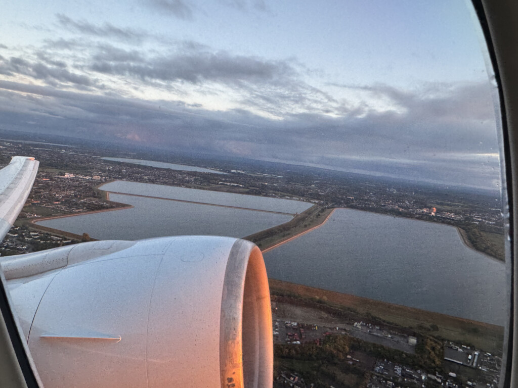 an airplane wing with a body of water and a city