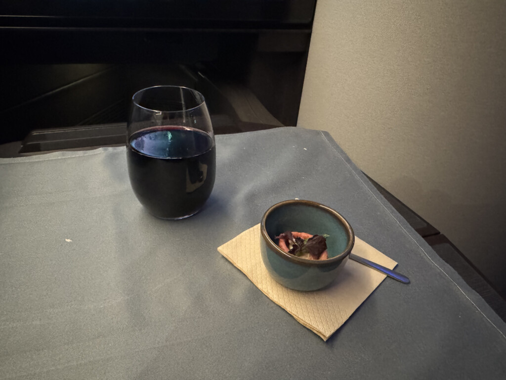 a glass of wine and a bowl of food on a table