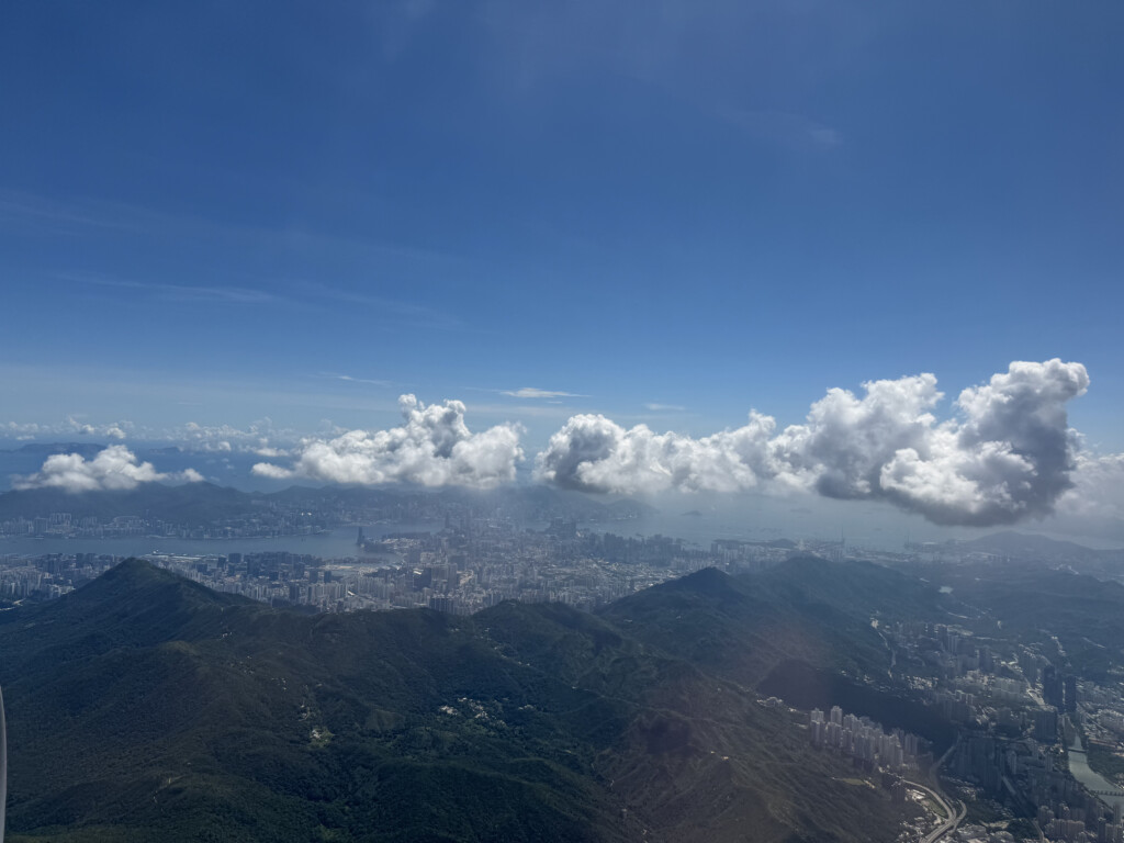 a cityscape with clouds above a mountain