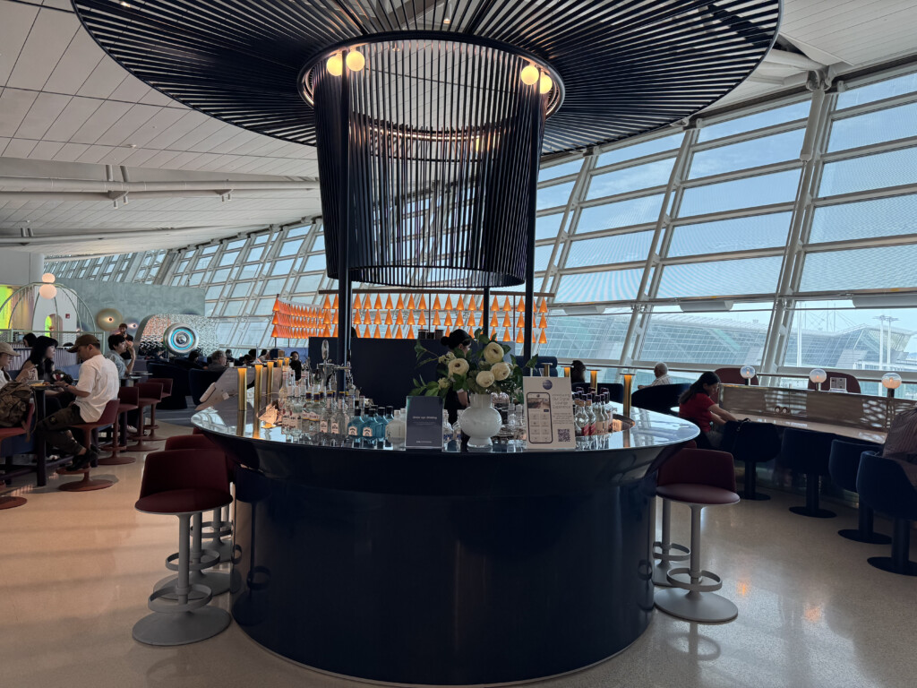 a bar with a large chandelier and a large glass ceiling