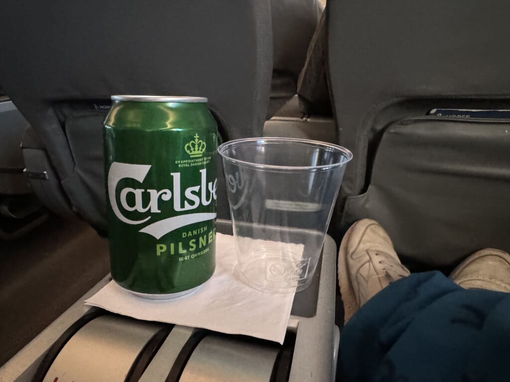 a green can and plastic cup on a seat