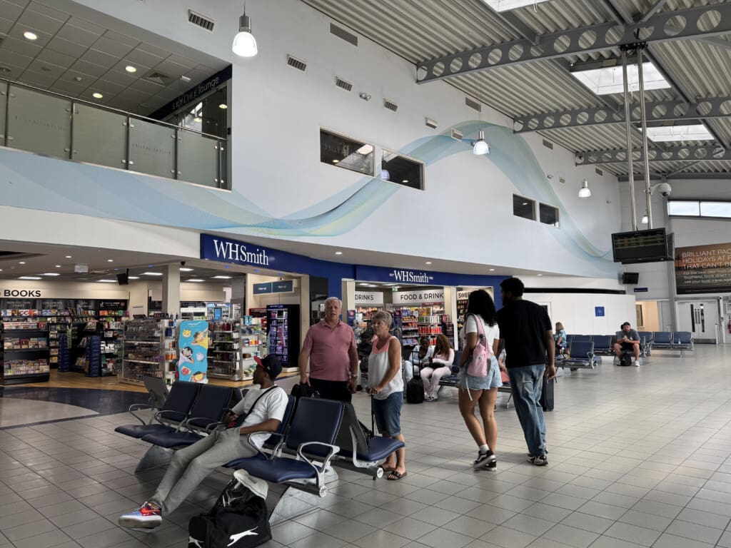 people in a terminal with people waiting for their flight
