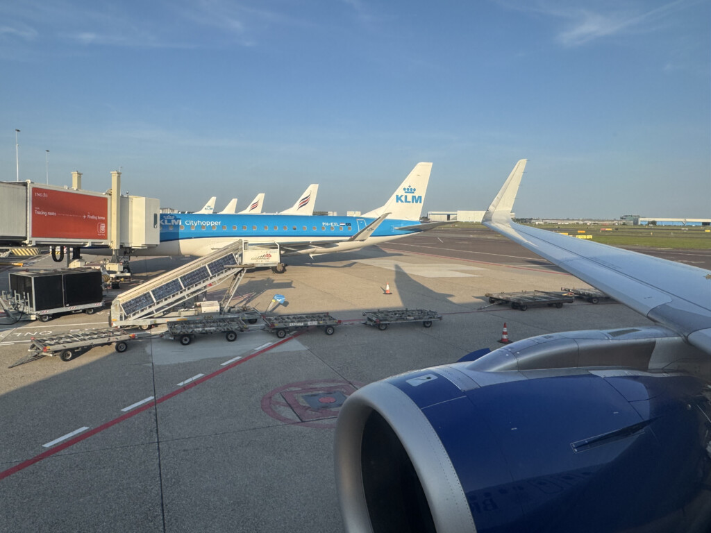 an airplane wing with blue and white planes on the ground