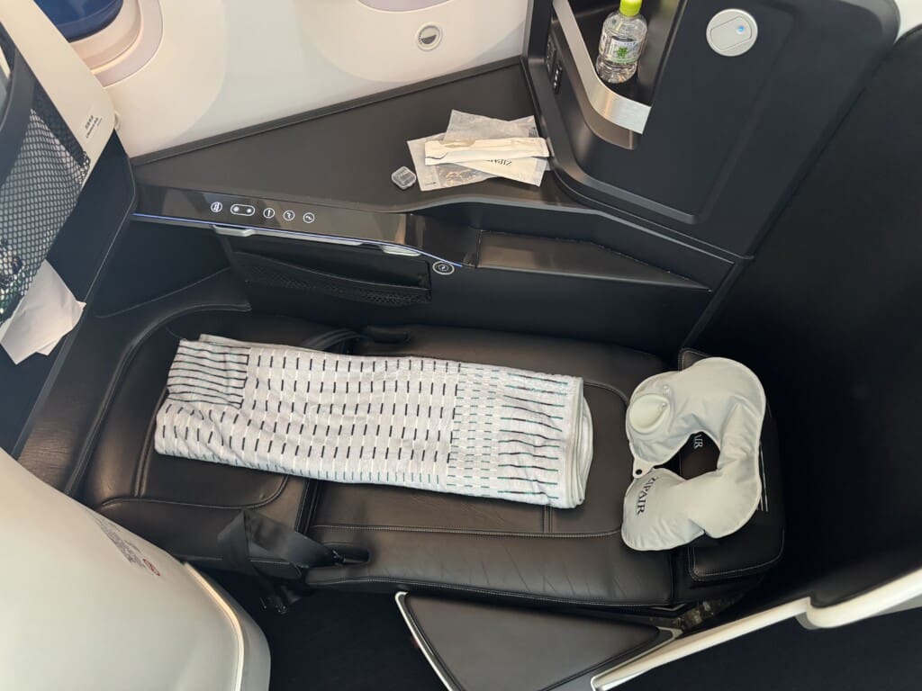 a seat with a pillow and a neck pillow on it