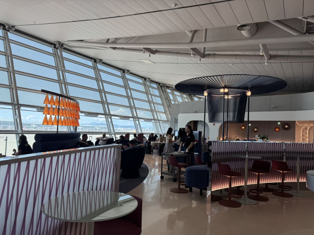 a room with a large window and people sitting at tables
