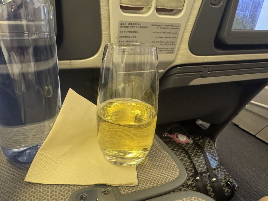 a glass of yellow liquid on a napkin on a table
