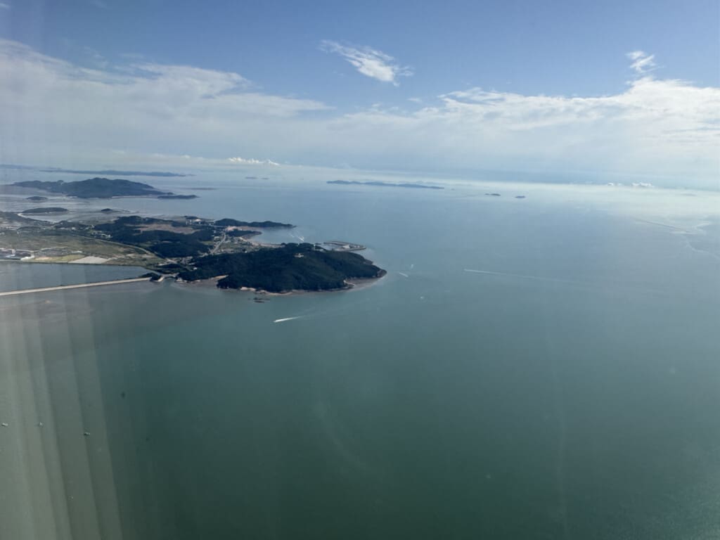 an aerial view of a body of water with land and buildings