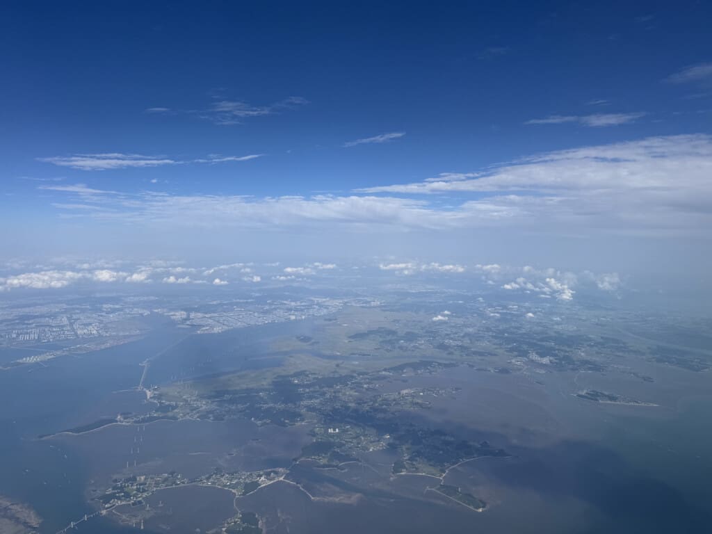 an aerial view of a body of water with buildings and clouds