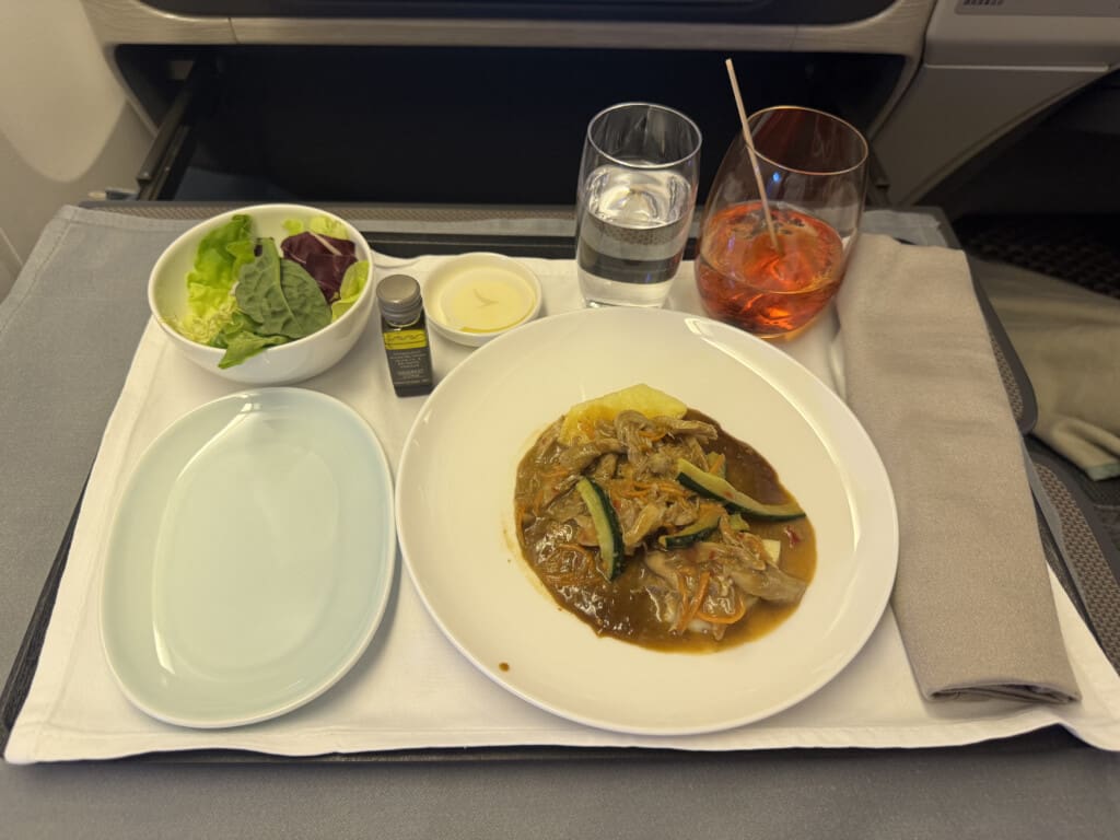 a plate of food and a glass of water on a tray