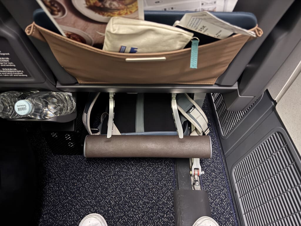 a seat with a bag and a paper roll