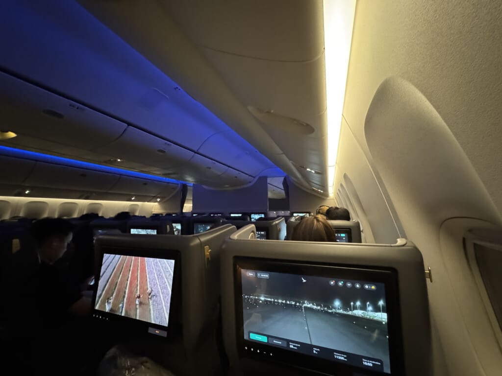 a row of seats with monitors on the side of the plane