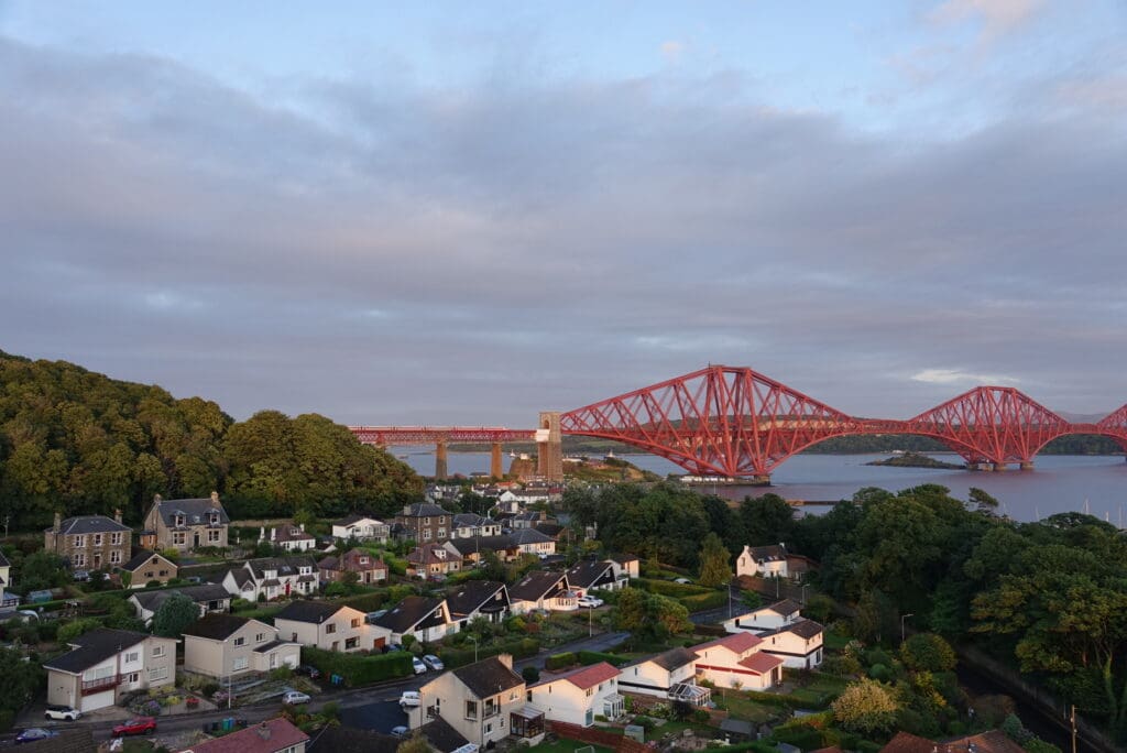 a red bridge over a river