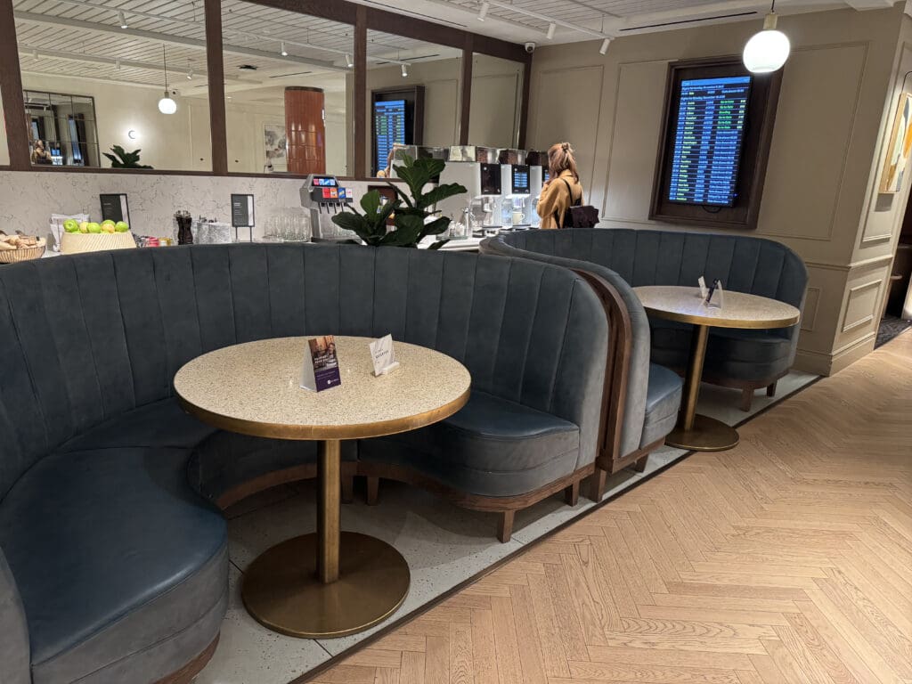 a room with a booth seating and a woman walking