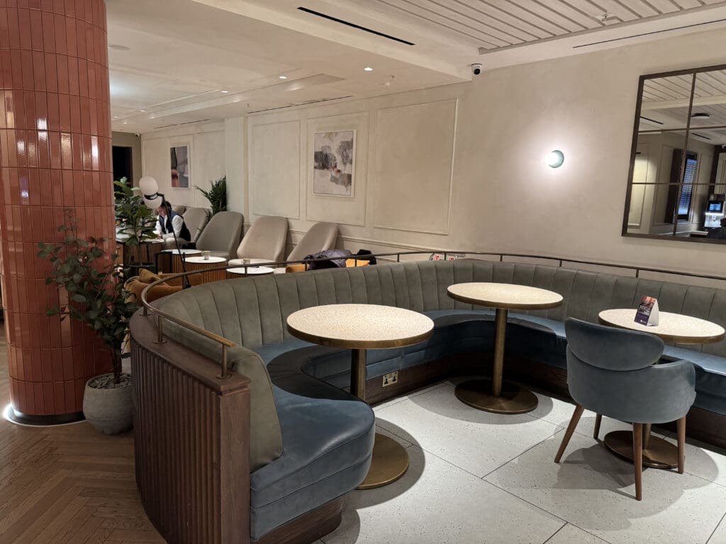 a room with a round booth and tables