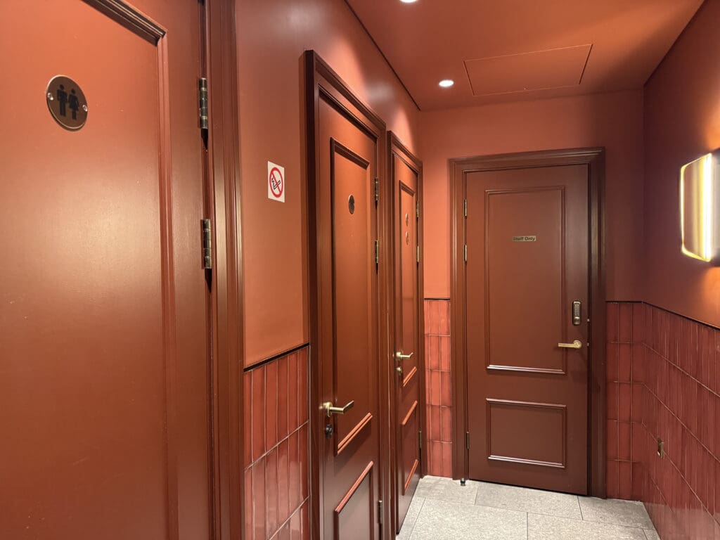 a hallway with brown doors and a red ceiling
