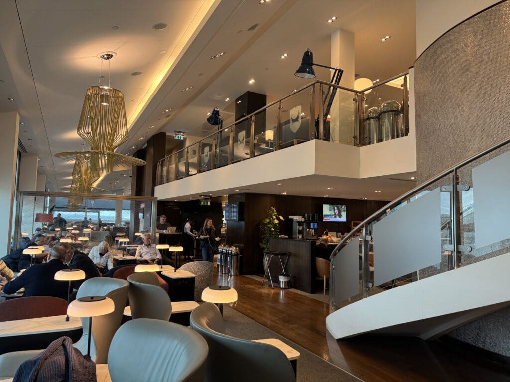 a room with a staircase and tables and chairs