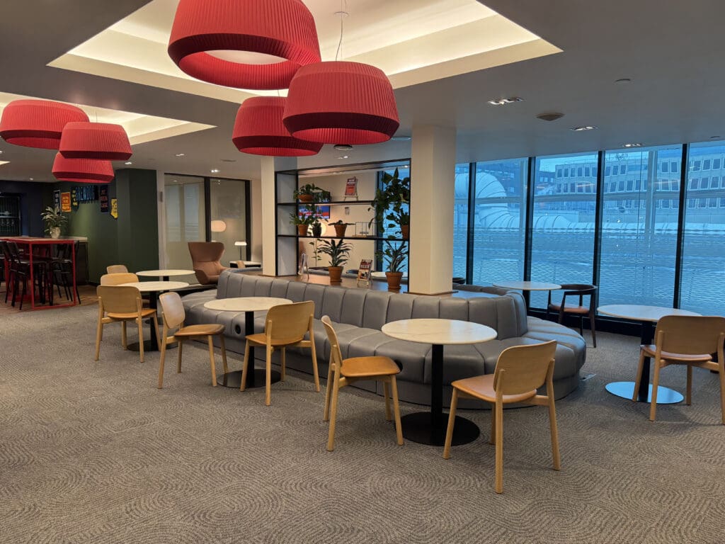 a room with tables and chairs and a large window