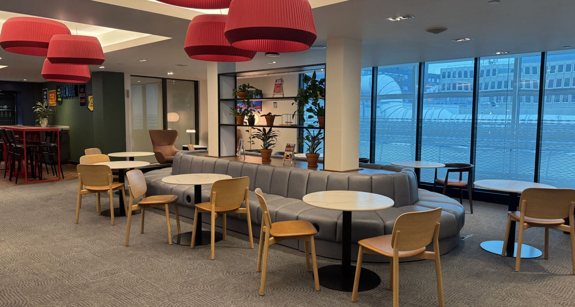 a room with tables and chairs and a large window