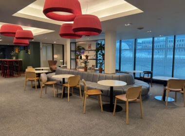 a room with tables and chairs and a large window