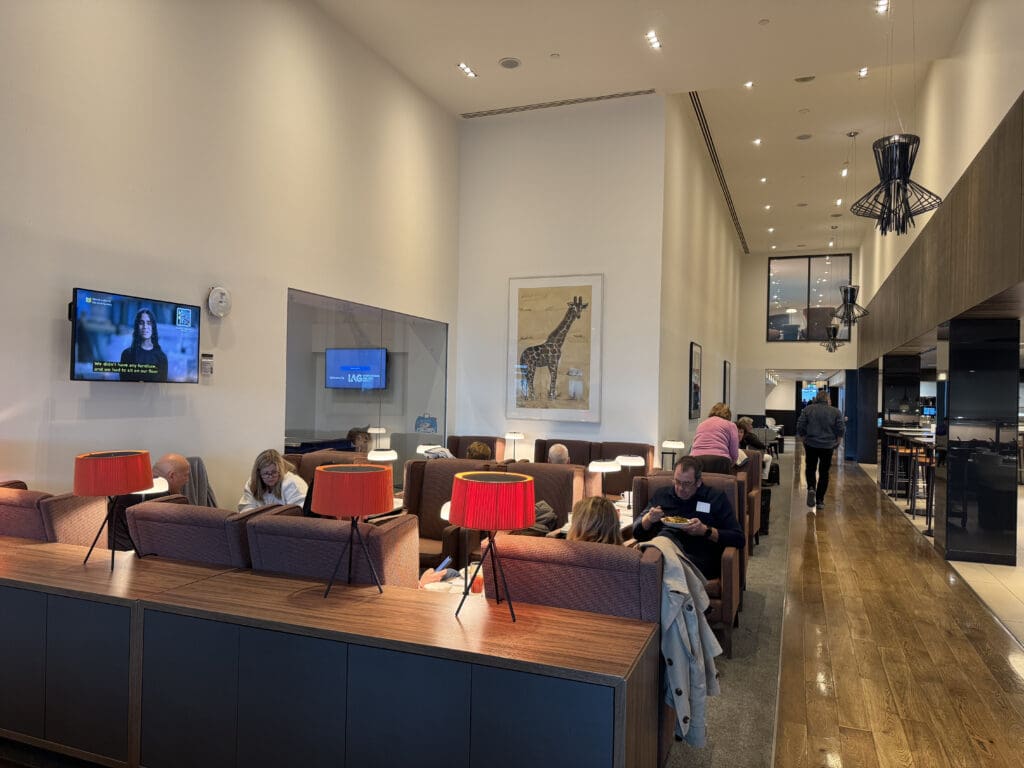 a group of people sitting in a room with tables and chairs
