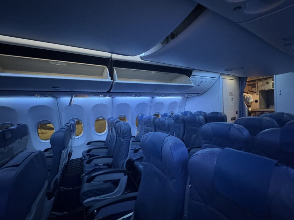 the inside of an airplane with blue seats