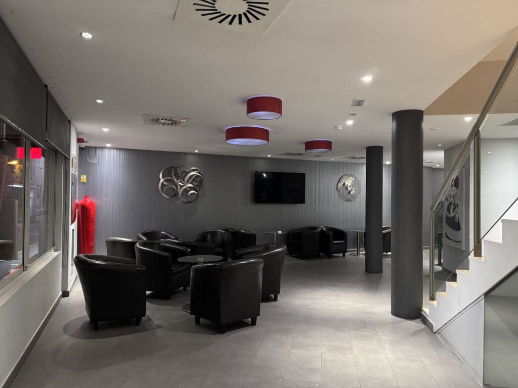 a room with black chairs and a television on the ceiling