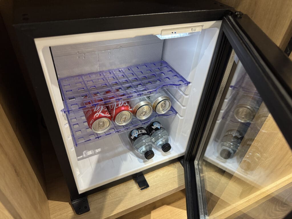 a mini fridge with cans of soda
