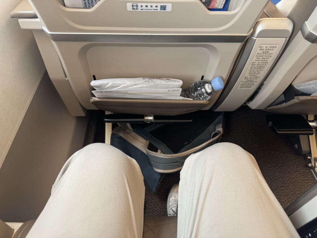 a person's legs and a tray with food in it